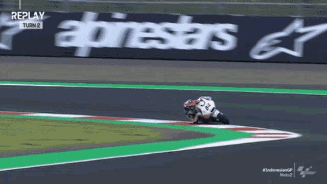 a person riding a motorcycle on a track with a sign that says replay turn 2