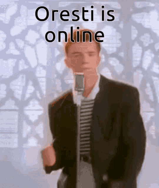 a man in a suit is singing into a microphone with the words oresti is online behind him