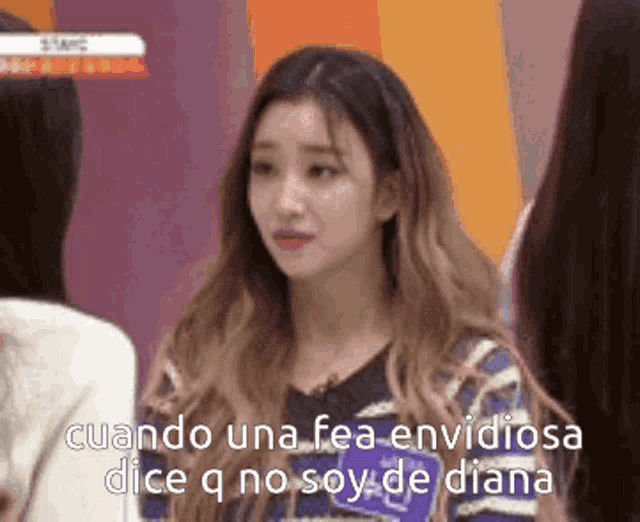 a girl with long hair is standing next to another girl and says cuando una fea envidiosa dice q no soy de diana .