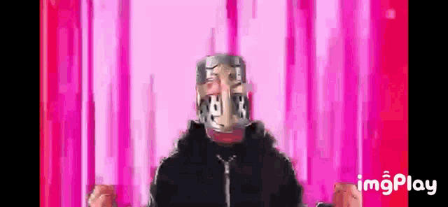 a man with a mask on his face is standing in front of pink lines .