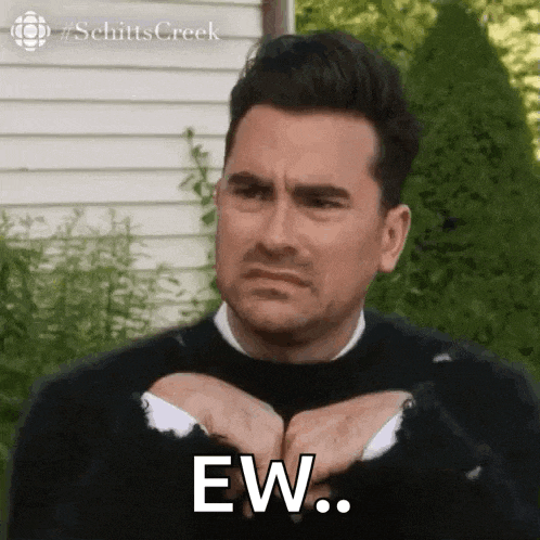 a man in a black sweater is making a funny face while holding his hands together and saying ew .