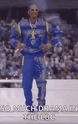 snoop dogg is walking down the runway at a fashion show in front of a crowd of people .