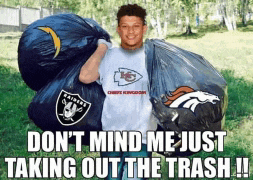 a man wearing a raiders shirt is holding a large trash bag