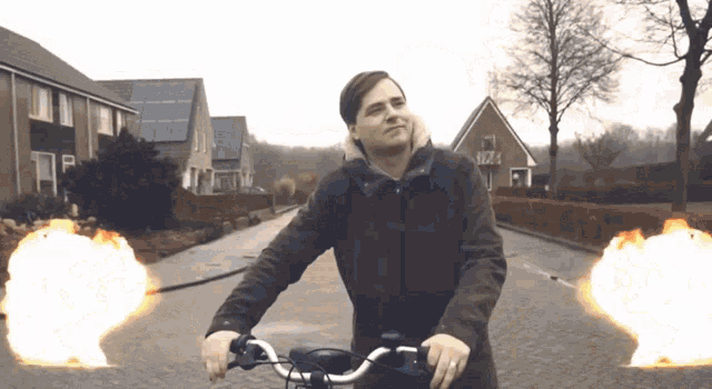 a man riding a bike down a street with a house in the background that says ' a '