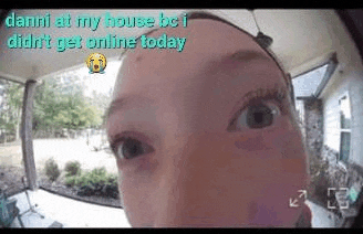 a close up of a woman 's face looking at the camera on a doorbell .