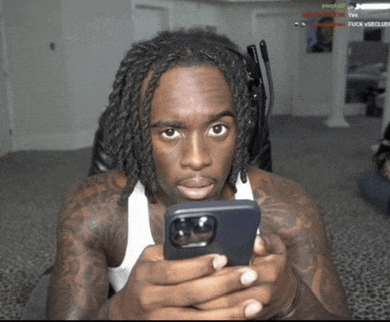 a man with dreadlocks is looking at his phone