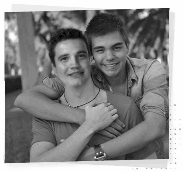 a couple of young men are hugging each other in a black and white photo .