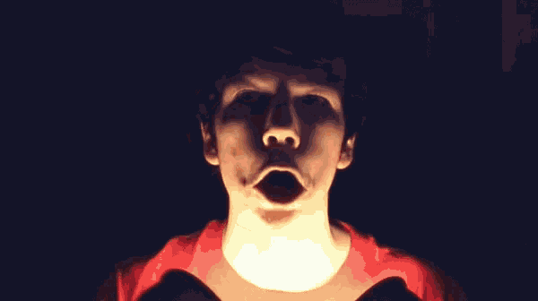 a man in a red shirt with his mouth wide open