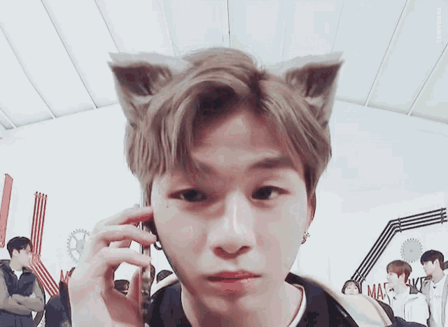 a man wearing cat ears is talking on a phone