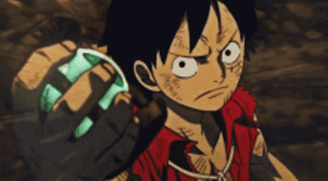 a monkey d luffy from one piece is holding a green object in his hand