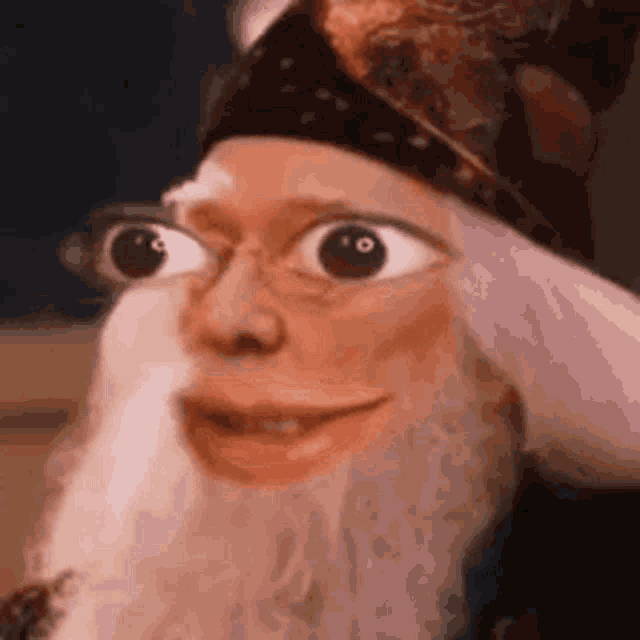 a close up of a man with a beard and glasses wearing a crown .