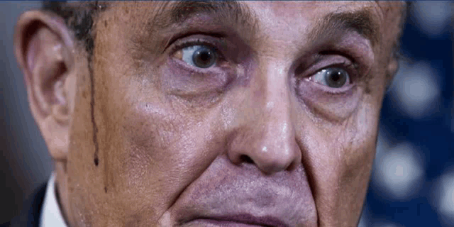 a close up of a man 's face with tears coming out of his eyes