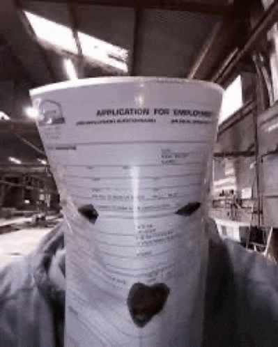 a person is holding a bucket with an application for employment on it .