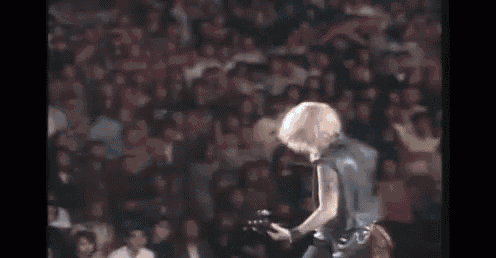 a blurry picture of a person standing in a dark room with a smoke coming out of their mouth .