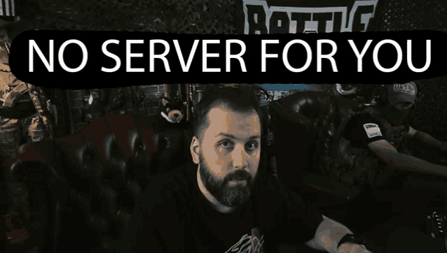 a man with a beard sits in front of a sign that says " no server for you "