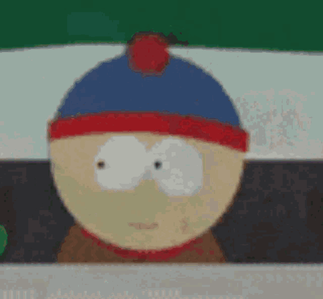 stanley from south park is wearing a blue hat with a red pom pom on top .