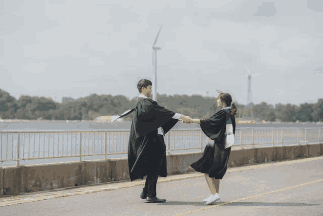 a man and a woman in graduation gowns are dancing