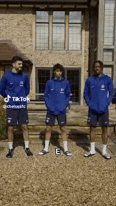 a group of soccer players are standing in front of a building .