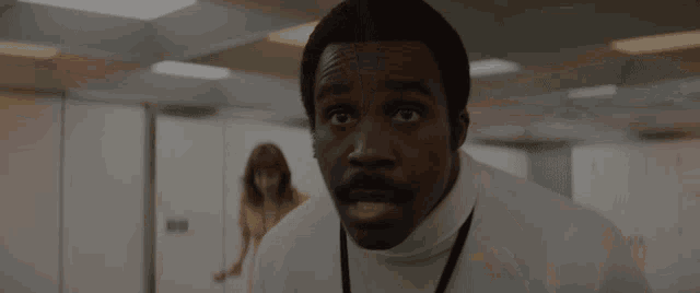 a man with a turtleneck and a lanyard around his neck