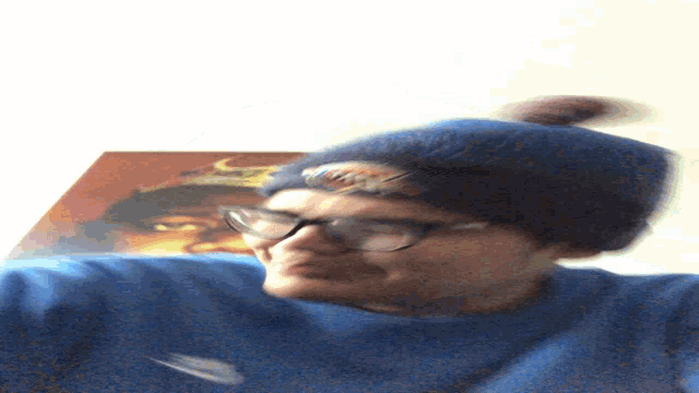 a blurry picture of a man wearing glasses and a blue shirt