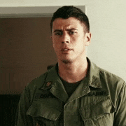 a man in a us army uniform is standing in a room