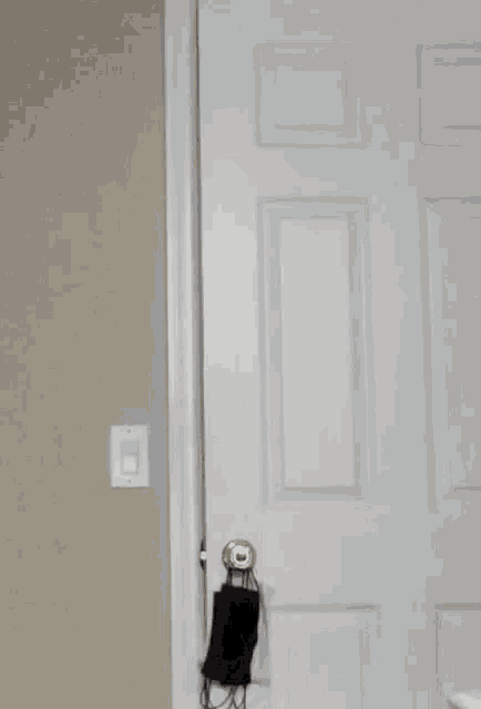 a man in a grey hoodie is peeking out of a door