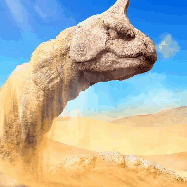 a statue of a camel in the desert with a blue sky in the background