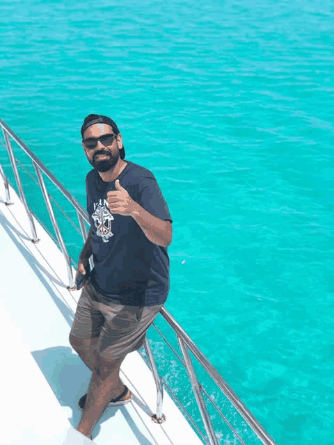 a man giving a thumbs up on a boat in the ocean