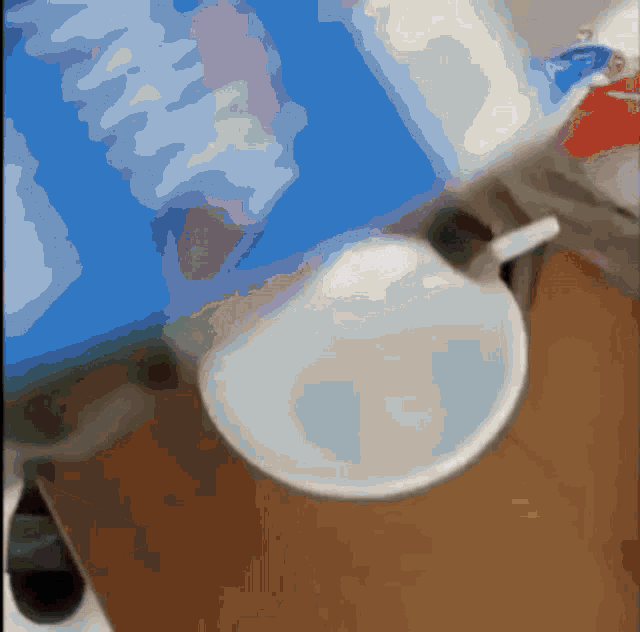 a white bowl is sitting on a wooden table