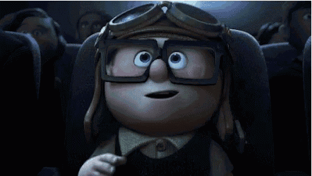 a cartoon character wearing goggles and glasses is sitting in a theater .
