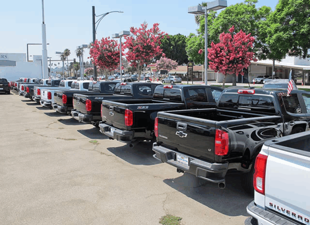 a row of silverado pickup trucks parked in a parking lot