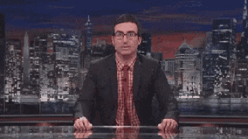 a man in a suit and tie is sitting at a desk in front of a city skyline