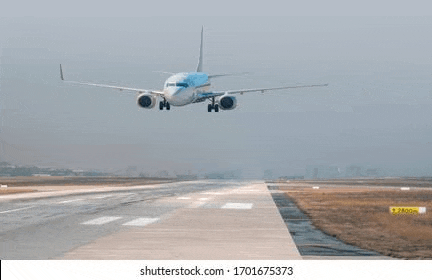 an airplane is taking off from an airport runway on a foggy day .