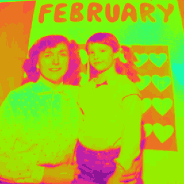 two people are standing in front of a colorful poster that says february