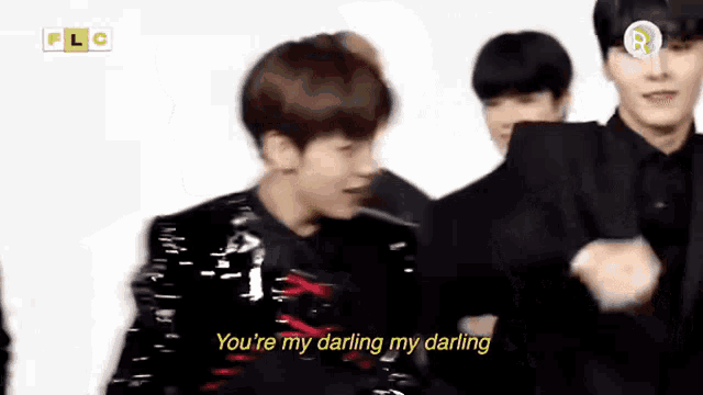 a group of young men are standing next to each other and dancing .