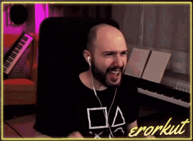 a bald man with a beard is wearing headphones and a black shirt that says erorkut