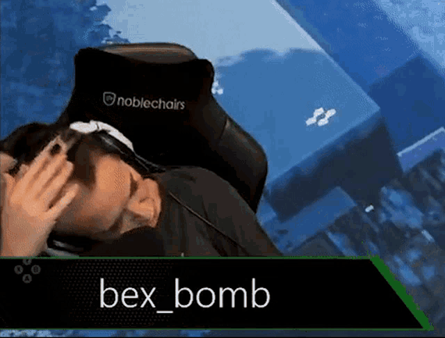 a man is laying in a noblechairs chair with his hand on his head .