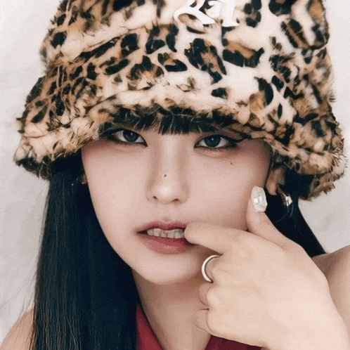 a woman wearing a leopard print hat and a ring