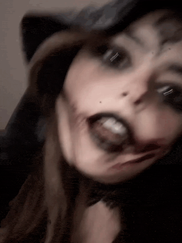 a woman with blood on her face is making a funny face