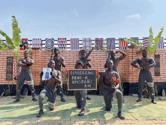 a group of men are posing for a picture with a sign that says ' i love you ' on it