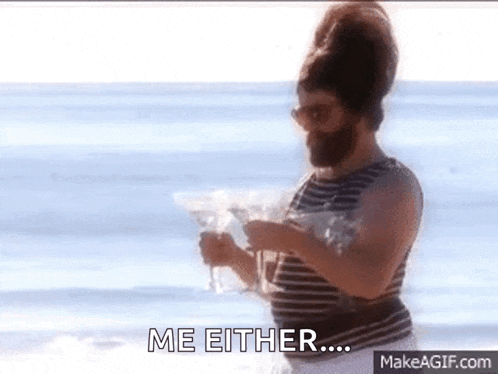 a man with a beard is standing on the beach holding a martini and says me either