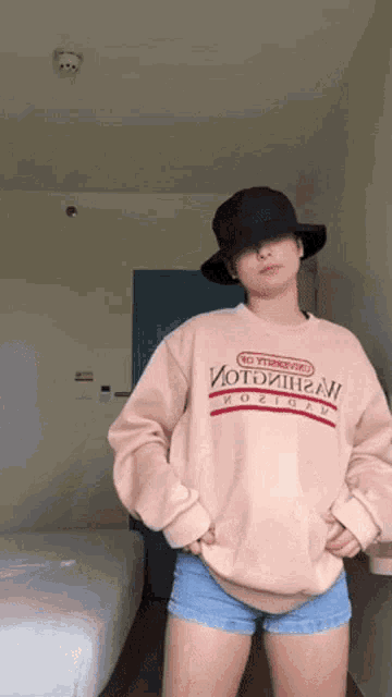 a woman wearing a hat and a sweater that says ' no transgenders ' on it