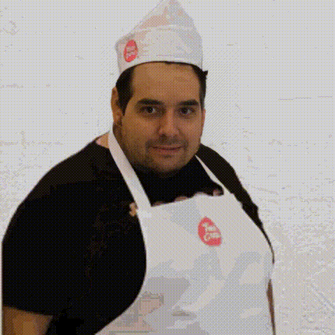 a man wearing an apron and a chef 's hat with a pizza hut logo on it