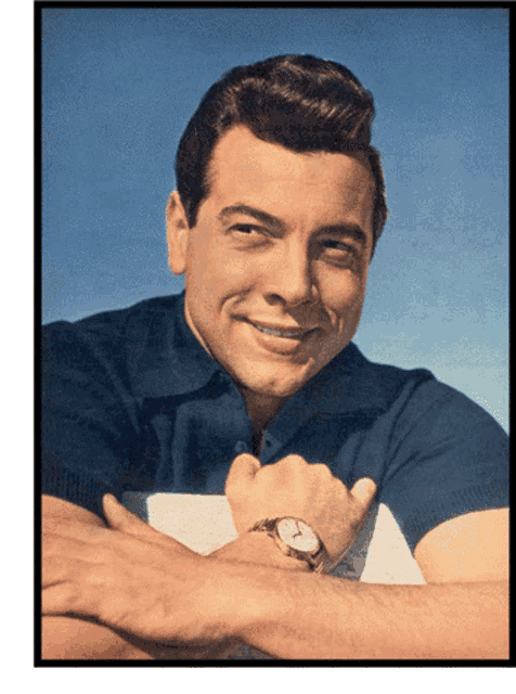 a man with a watch on his wrist smiles for the camera