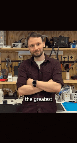 a man with his arms crossed stands in front of a workbench with the words " the greatest " written on the bottom