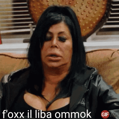 a woman with huge breasts is sitting on a couch and says foxx il liba ommok .
