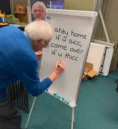 an elderly man writes on a white board that says stay home if u sicc come over if u thicc