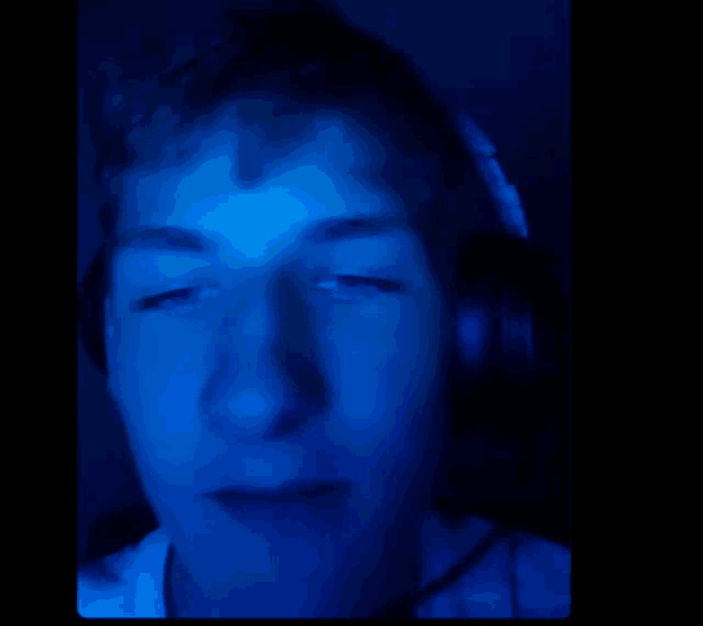 a close up of a person 's face with a blue light behind him