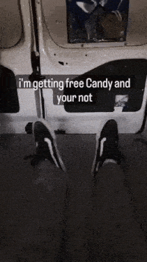 a person 's feet in a van with the words " i 'm getting free candy and your not " above them