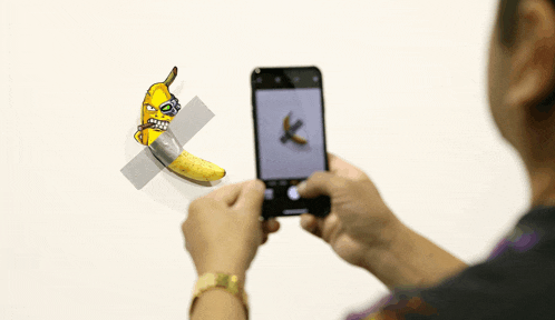 a person is taking a picture of a banana with a knife on it